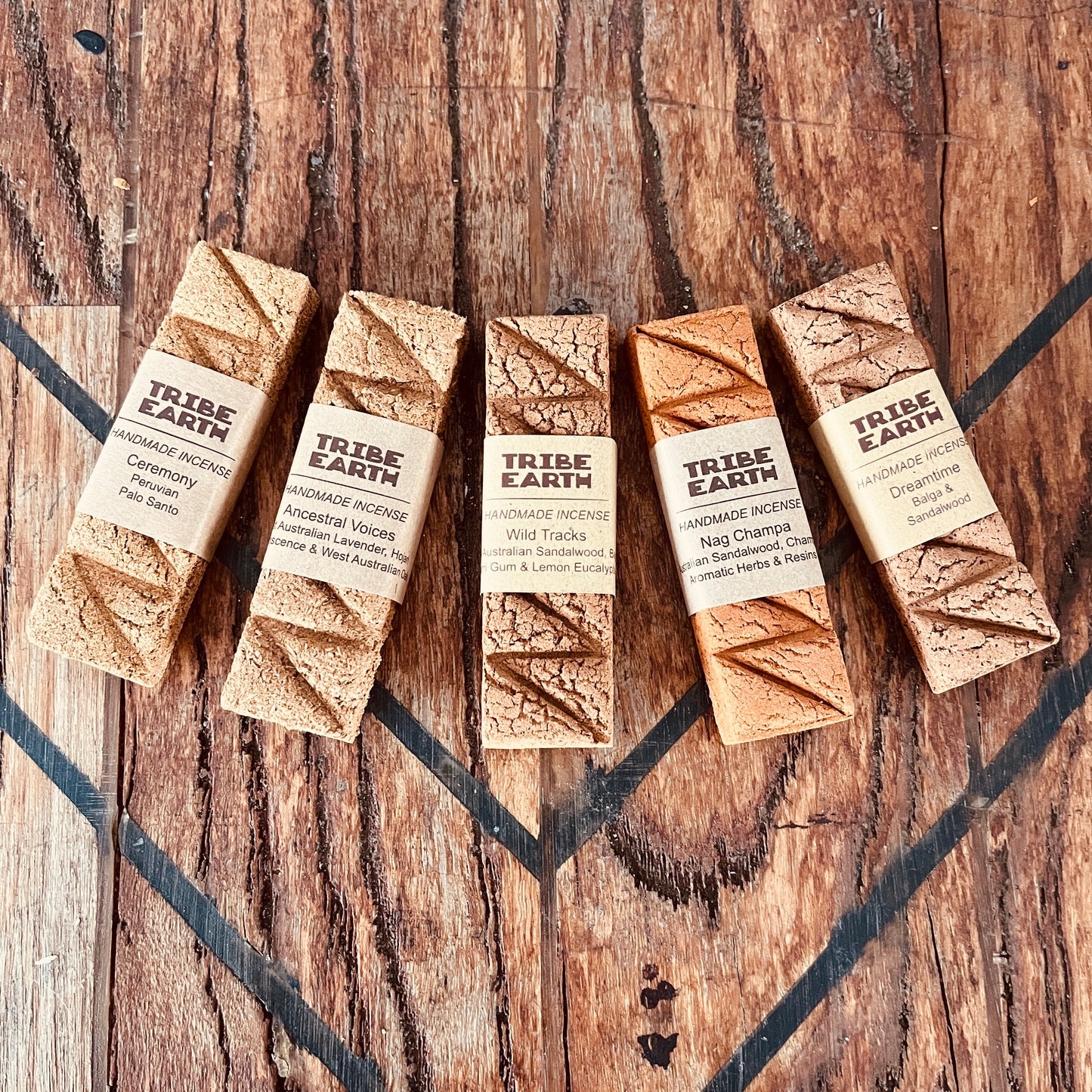 Five Tribe Earth product packages on a wooden surface