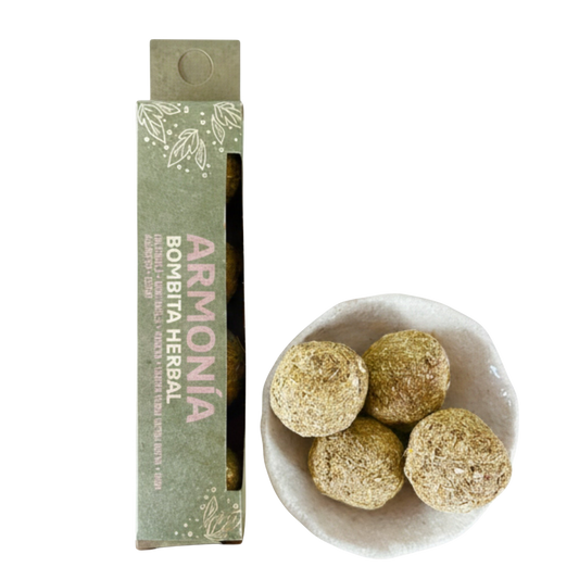 Herbal balls in a bowl with packaging labeled 'Armonía Bombita Herbal' on a white background