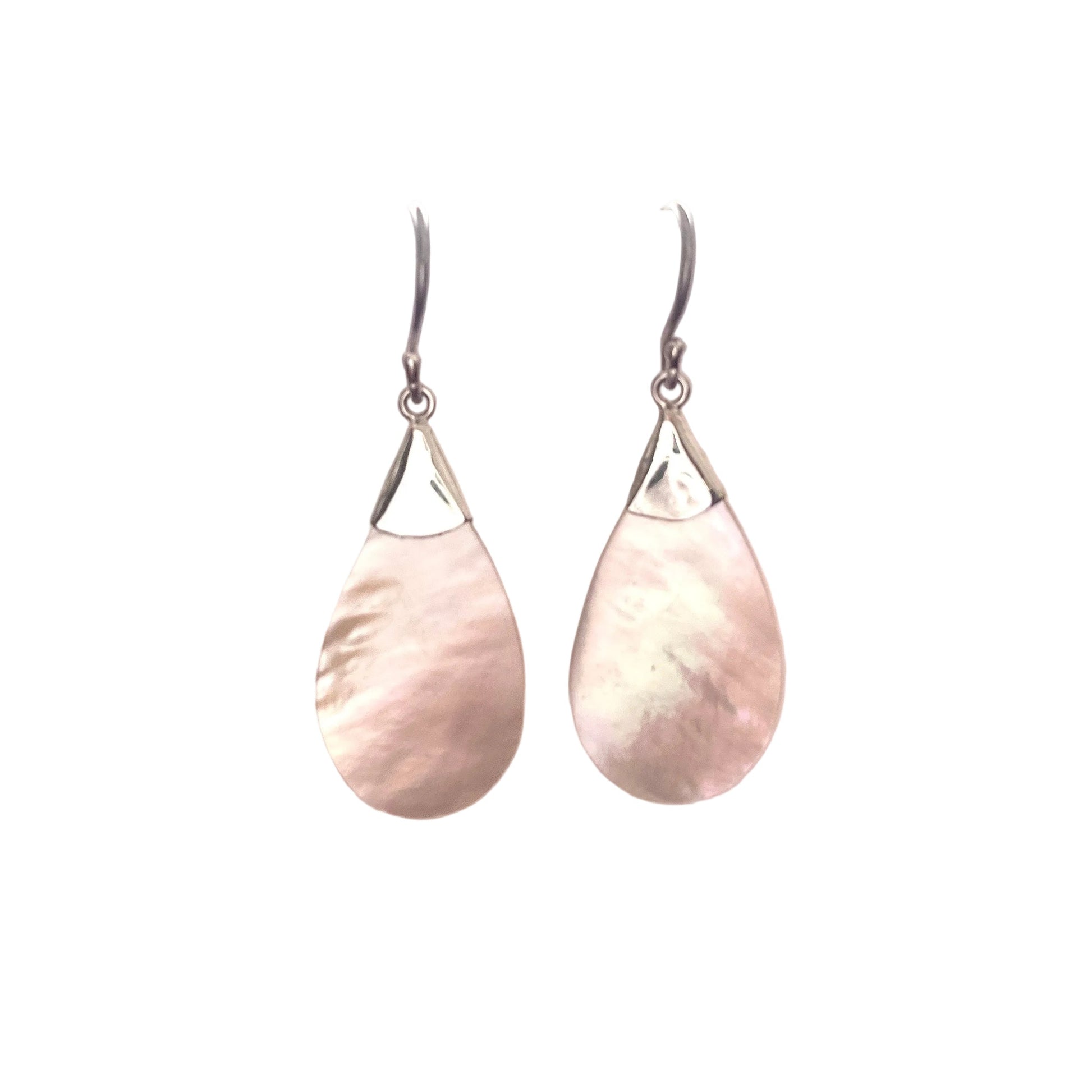Teardrop-shaped earrings on a white surface with a blurred background