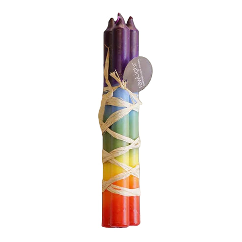 Set of rainbow-colored candles with a purple top, wrapped in twine, on a beige background.