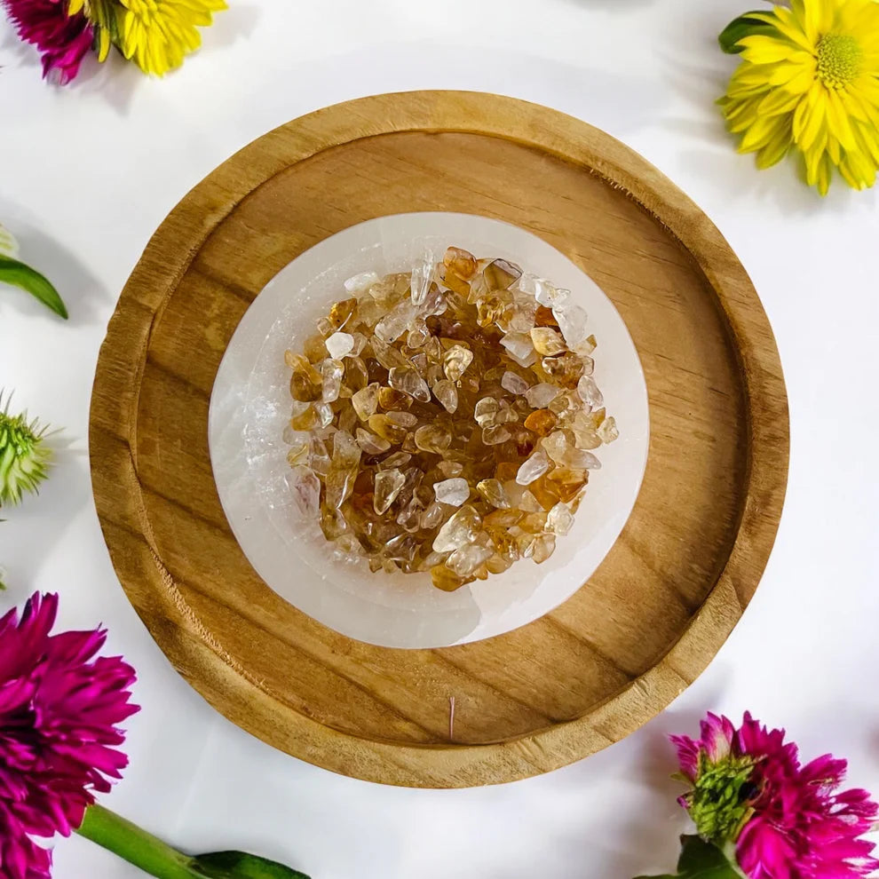 Wooden plate with a citrine crystals on a white background with flowers