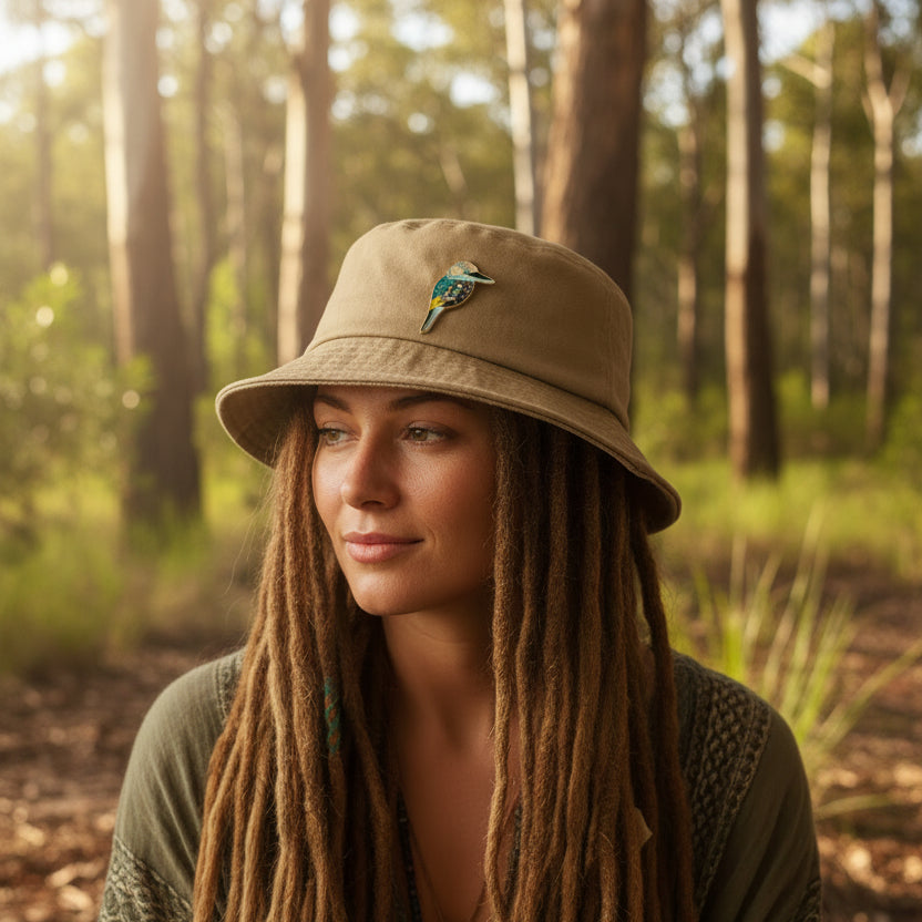 Enamel pin of a kookaburra on a hat worn by a hippy boho lady n the bush