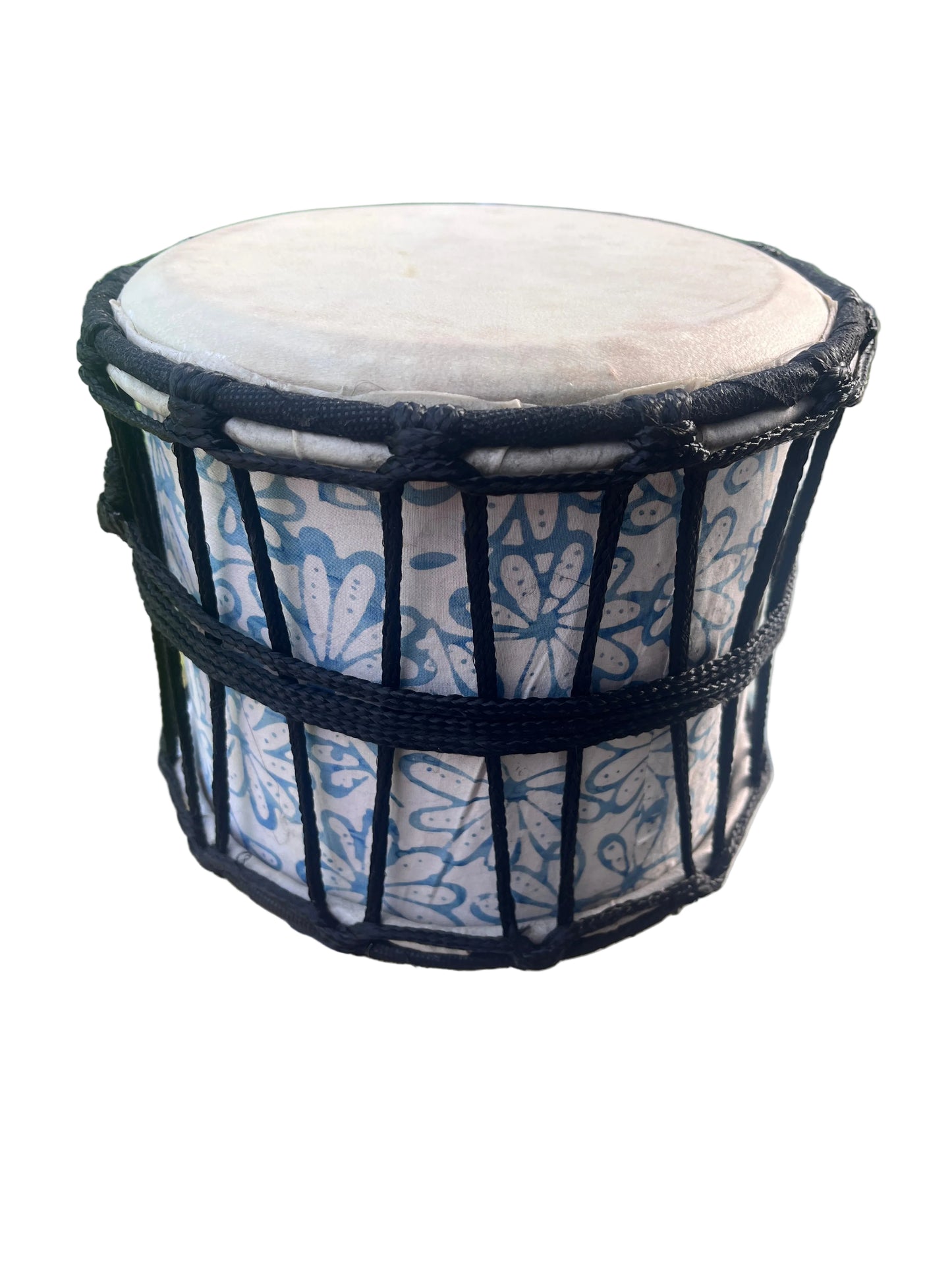 A handcrafted drum with a blue and white floral patterned body, black rope tensioning, and a natural beige drum head