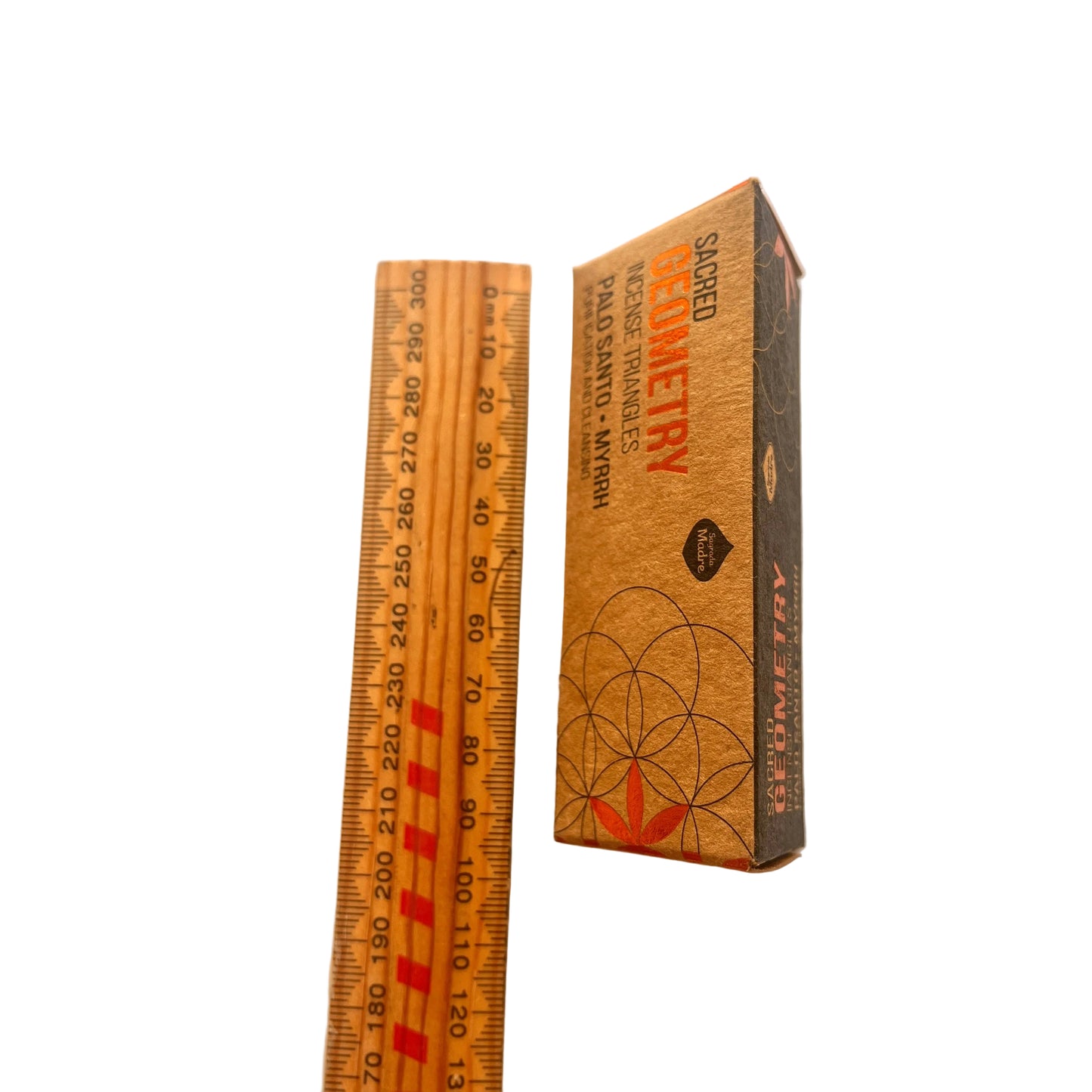 Wooden ruler and box with 'Sacred Geometry' design on a white background