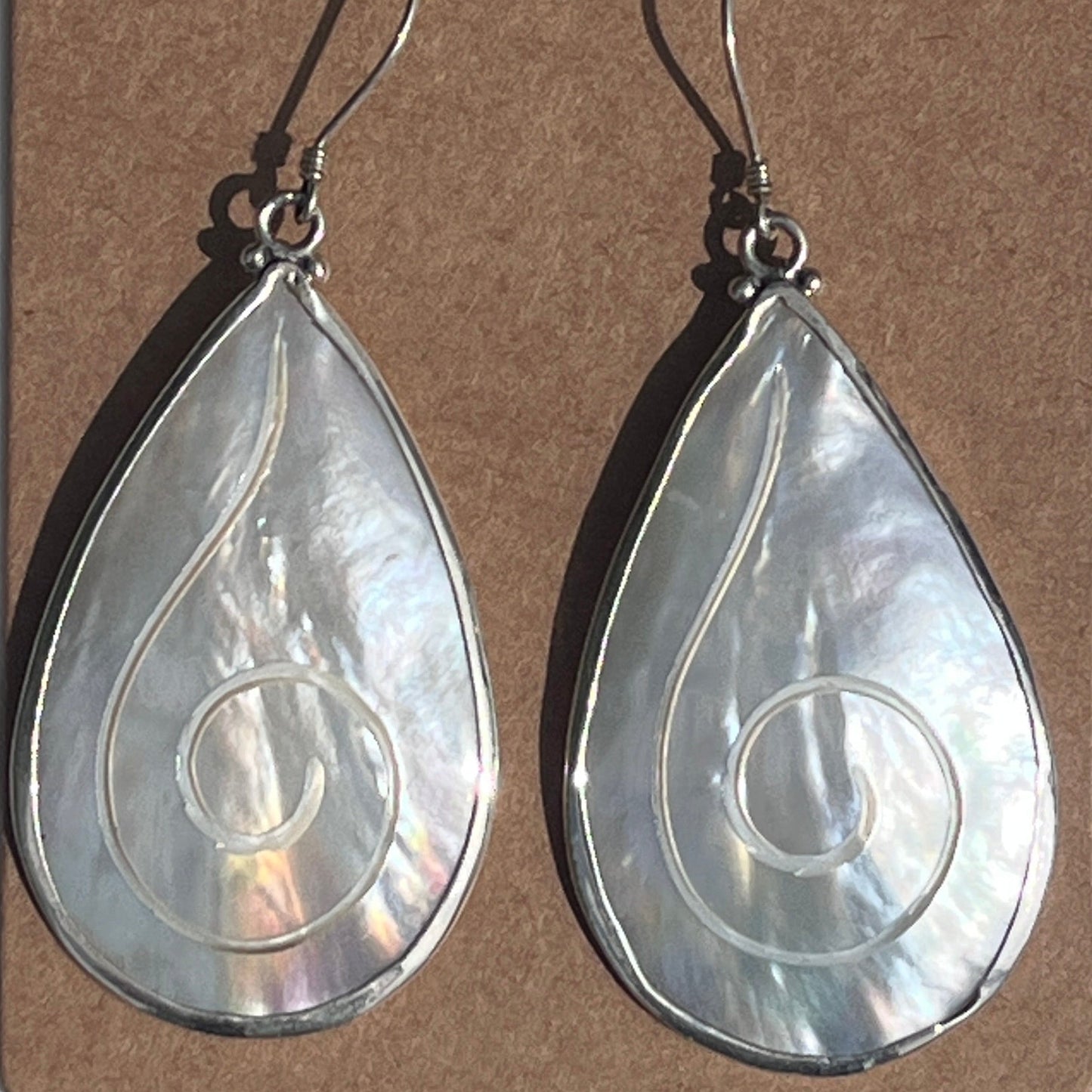 Teardrop-shaped earrings on a 'The Crescent Moon' branded card against a white background