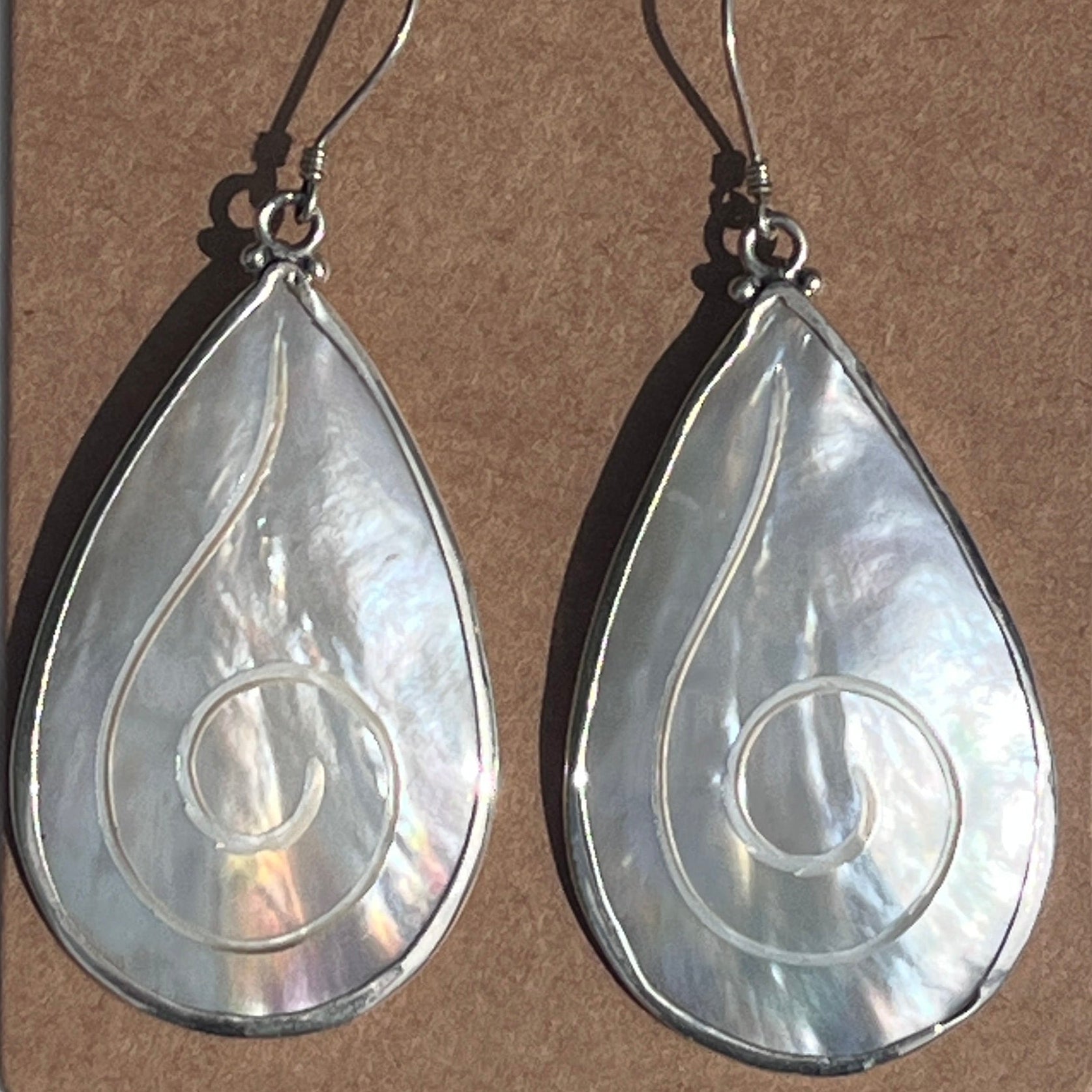 Teardrop-shaped earrings on a 'The Crescent Moon' branded card against a white background