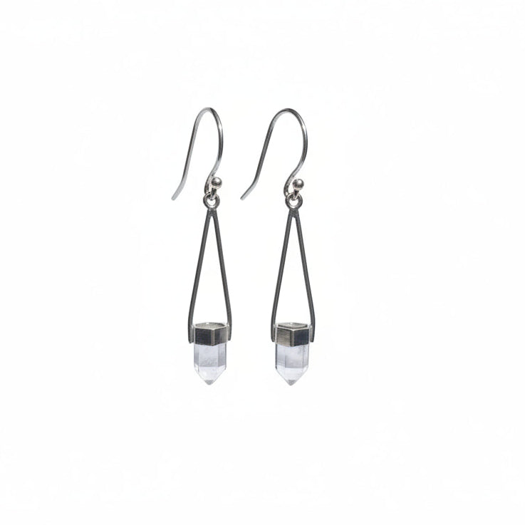 Pair of silver earrings with clear crystal drops hanging  against a light gray background.