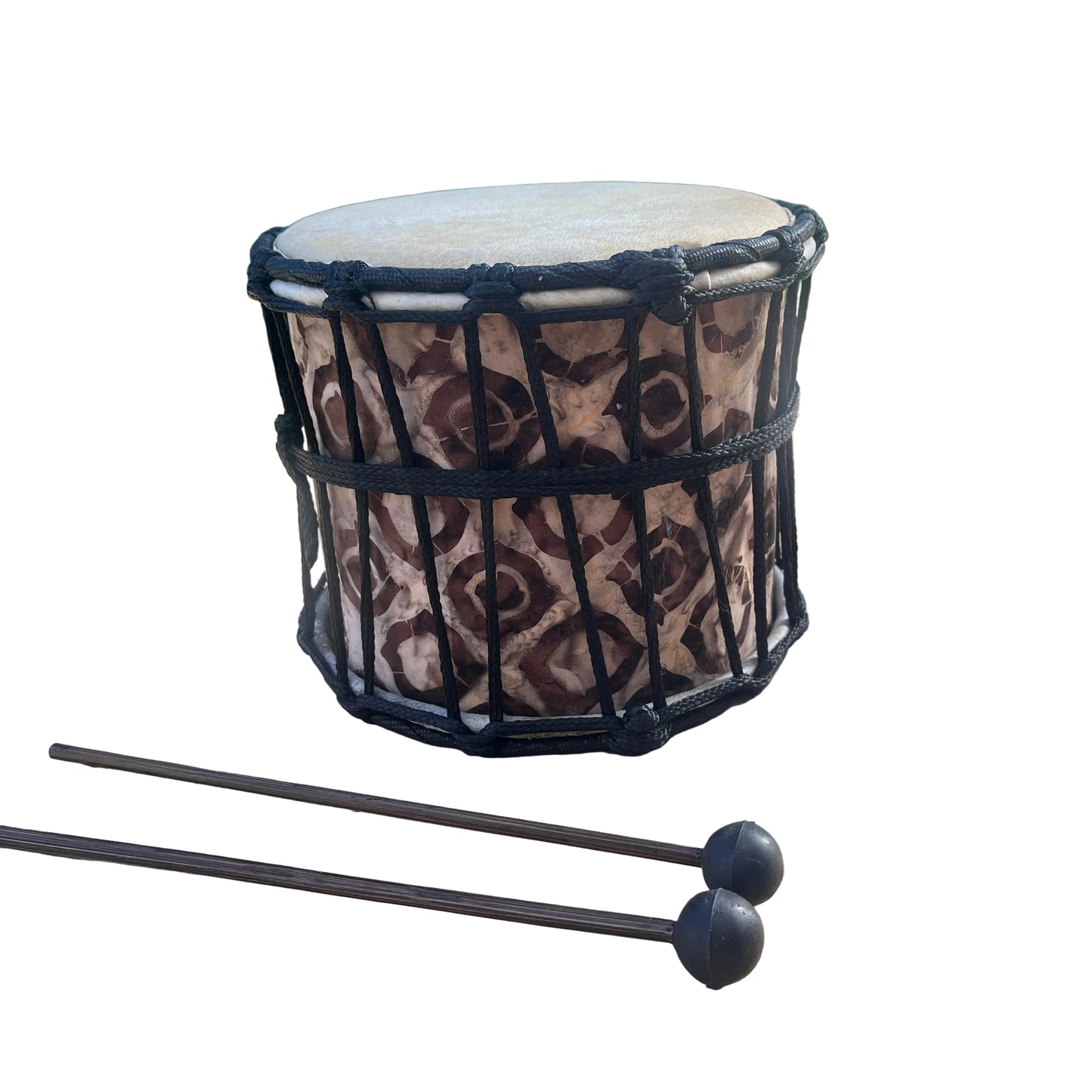 A hand drum with a brown and beige patterned body, black rope tensioning, and two black mallets, 
