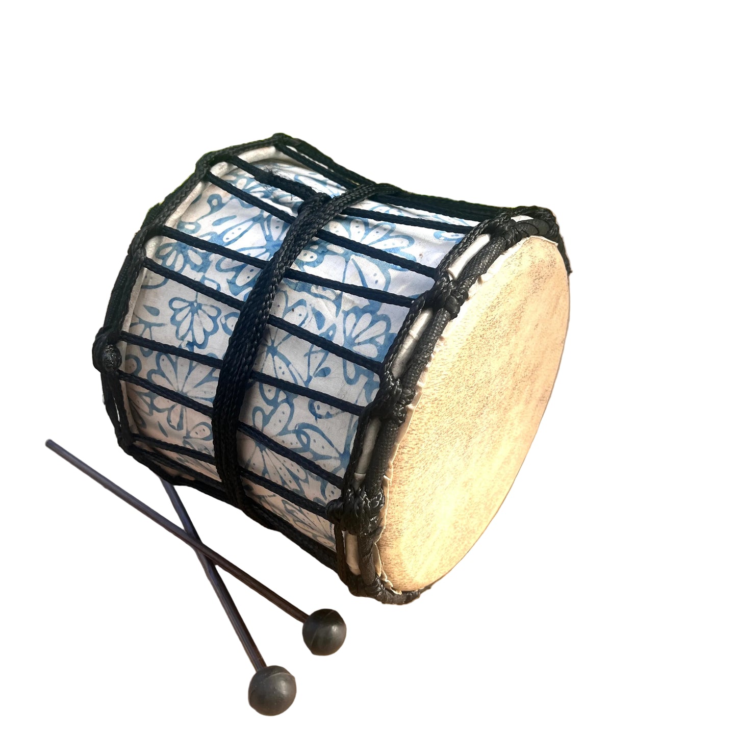 A hand drum with a beige skin-covered head and a white body patterned with blue floral motifs, wrapped in black cord