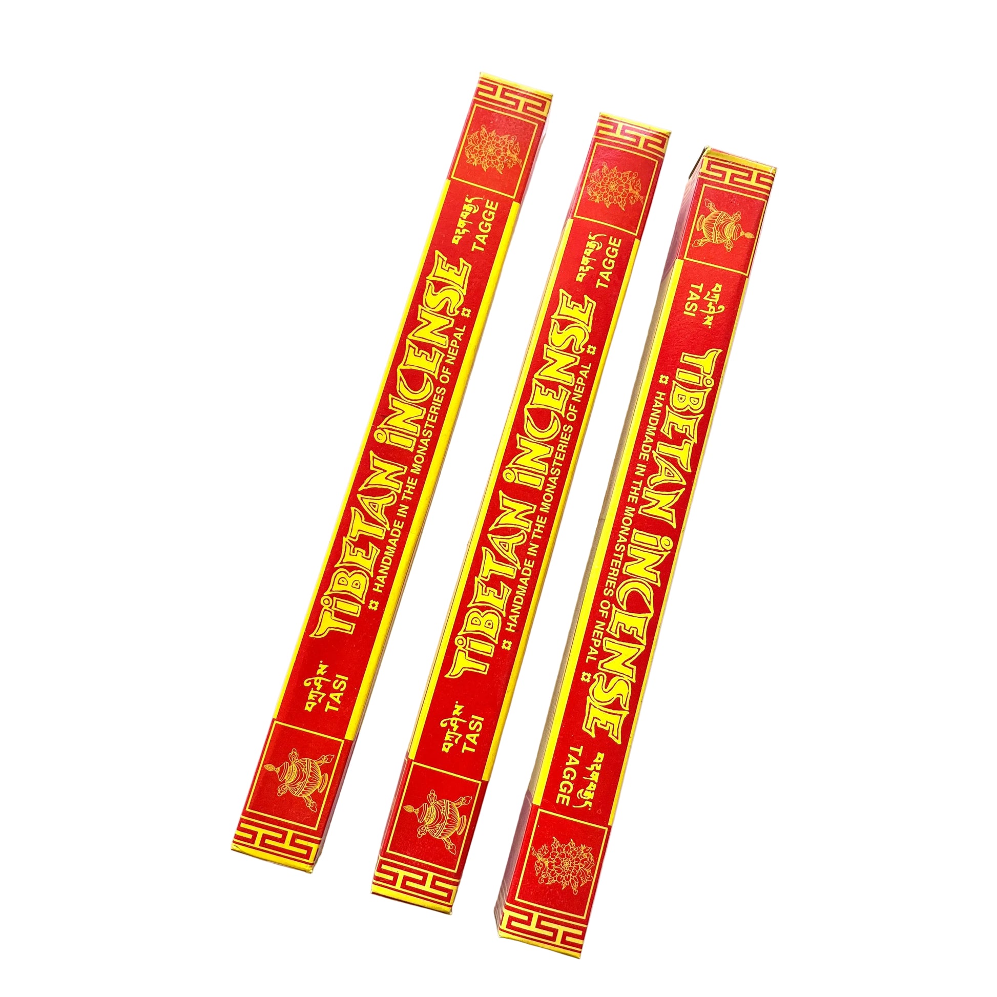 Three sticks of Tibetan incense on a white paper with a patterned background