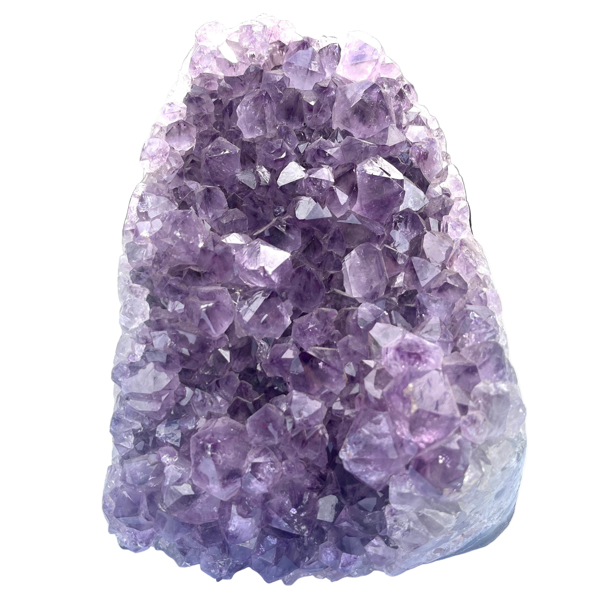 Amethyst crystal cluster on a white surface with a blurred background