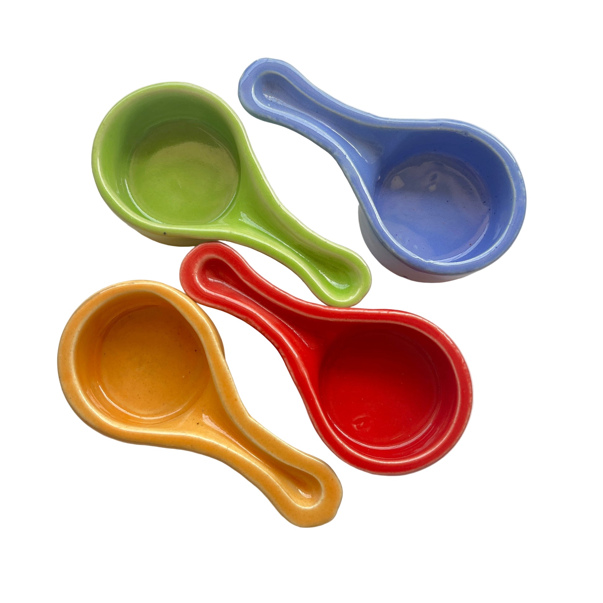 Four colorful ceramic charcoal burners on a white surface