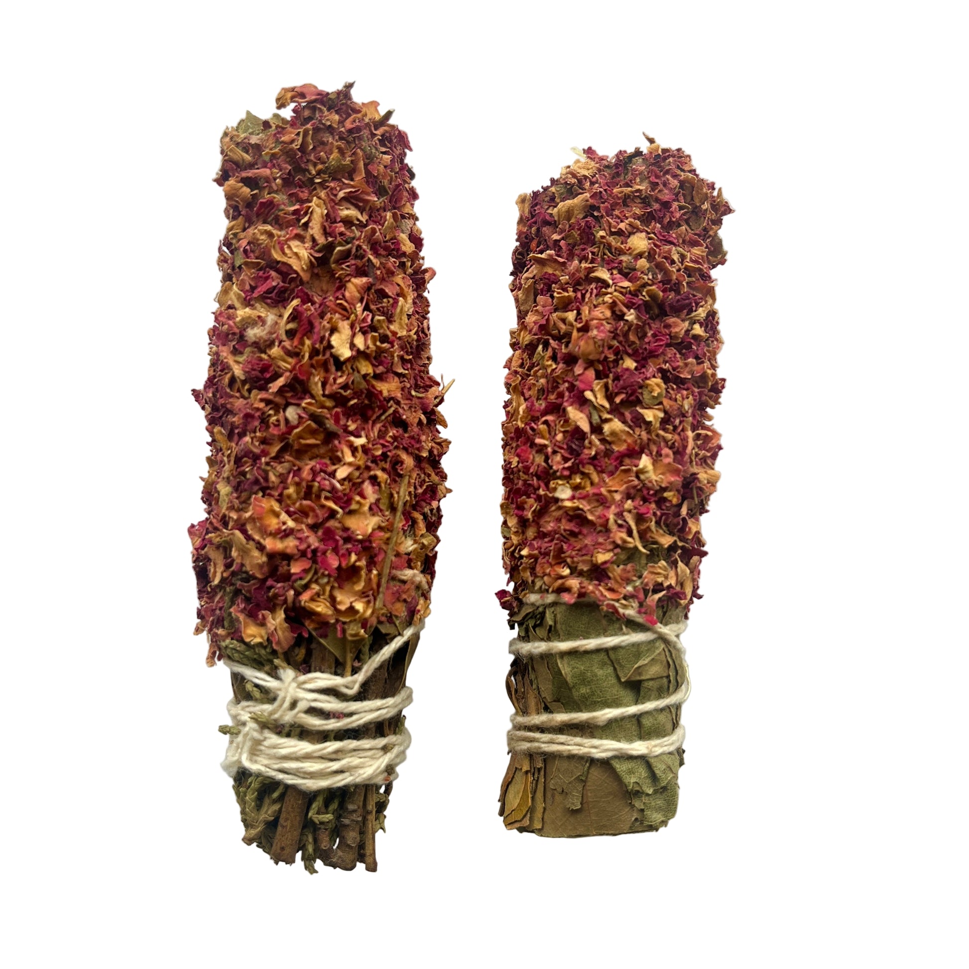 Two bundles of dried herbs tied with twine on a white background