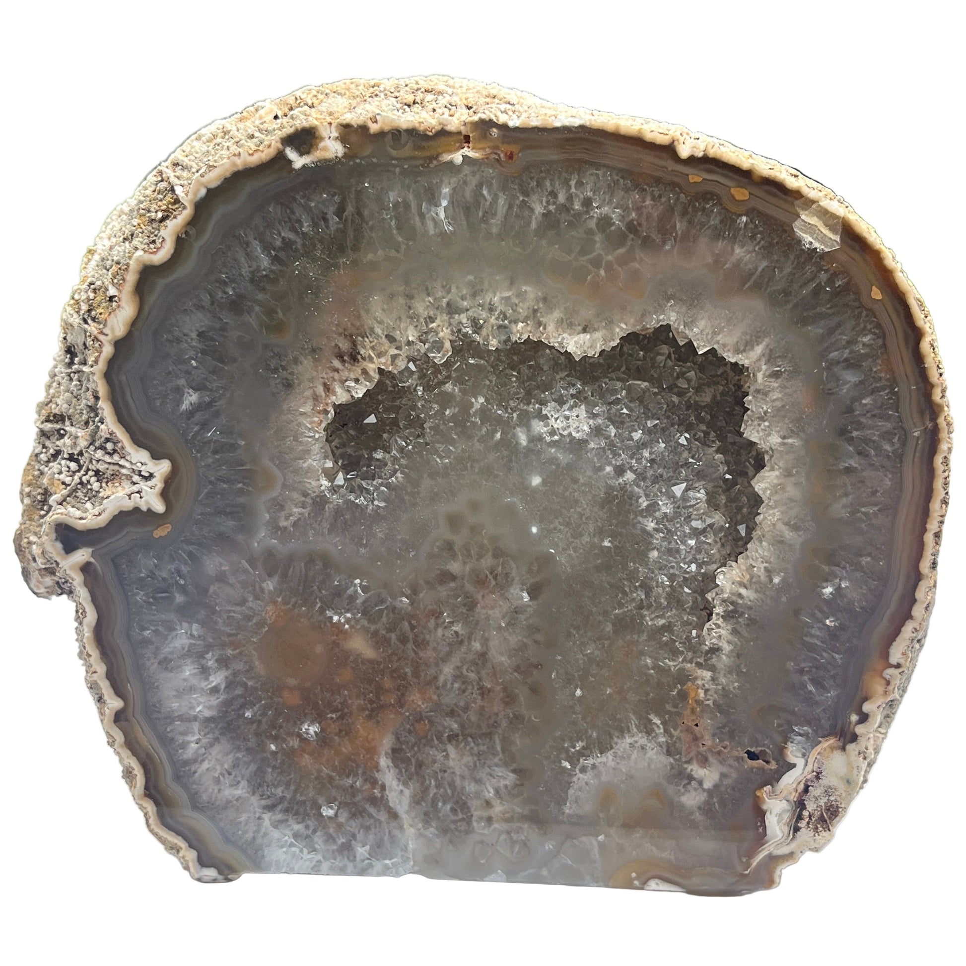 Geode cut open to reveal its interior on a white surface with a white background