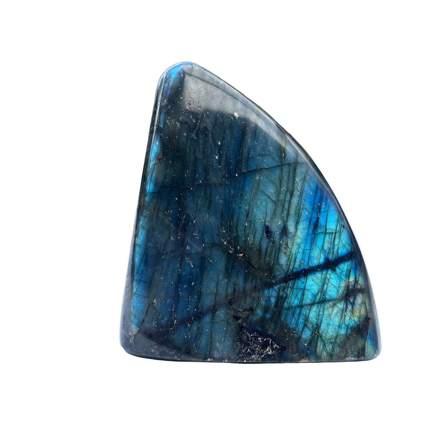 Labradorite stone on a white surface with a blurred outdoor background