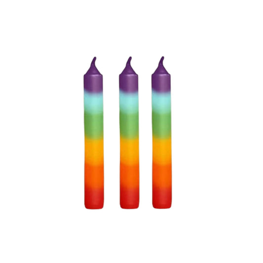 Three rainbow-colored candles on a white background