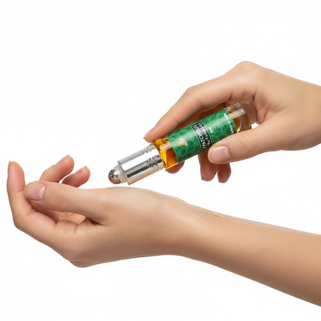Patchouli perfume oil with green label being rolled onto a wrist