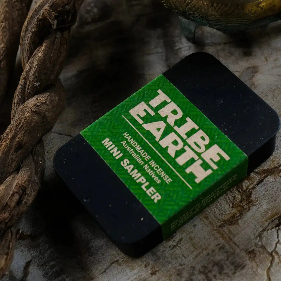 Tribe Earth mini sampler packaging on a textured surface with natural elements.