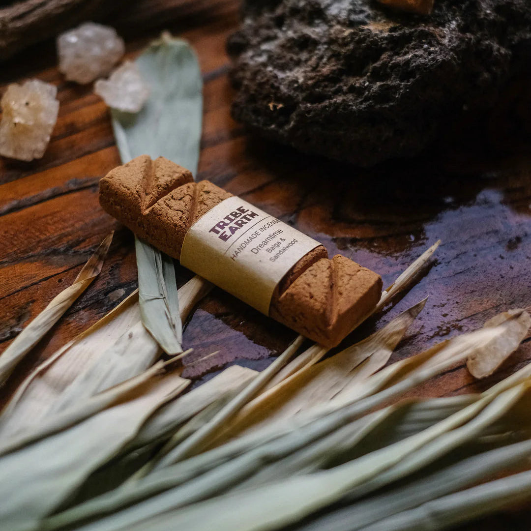 Tribe Earth Incense with a label on a wooden surface with leaves and crystals