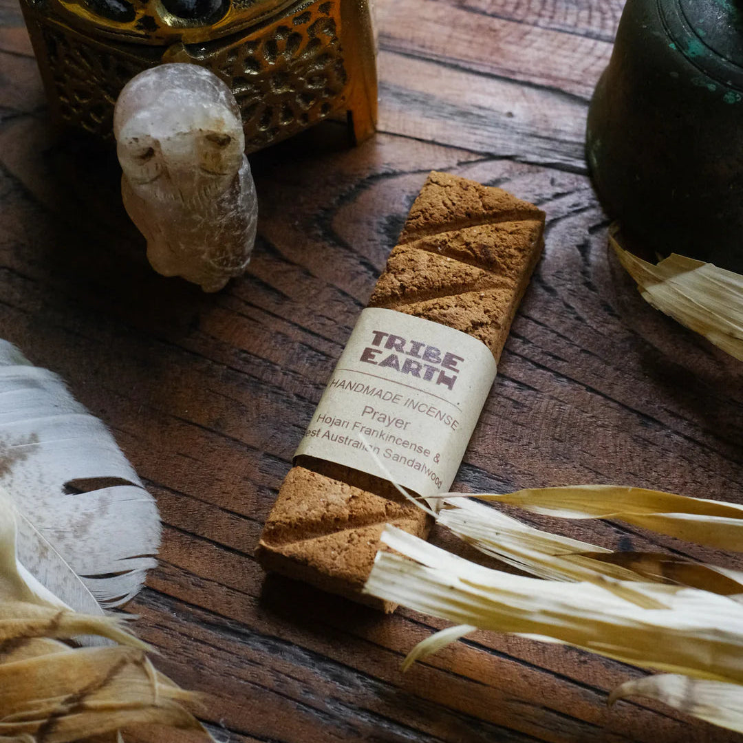 Tribe Earth handmade incense stick package on a wooden surface with natural items.