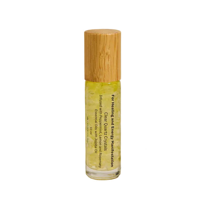 Roller bottle with clear quartz crystals by Cedarwood road with bamboo cap on a neutral background