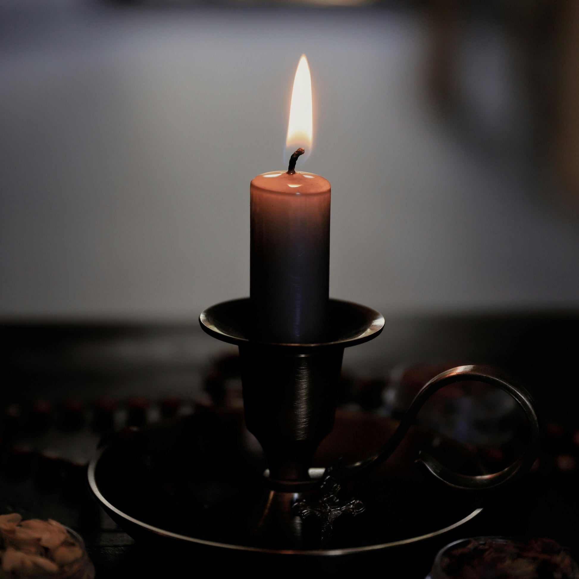 brown spell candle in a holder with a blurred background