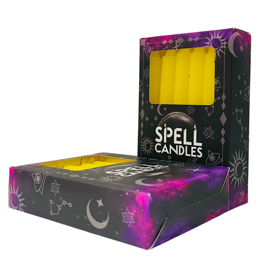 Box of yellow spell candles with black and purple design on a white background